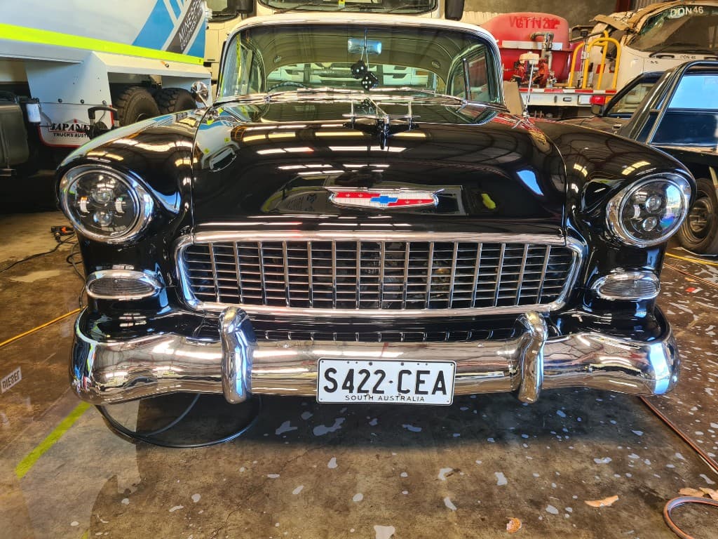 Same classic Chevrolet after paint correction with mirror-like black gloss